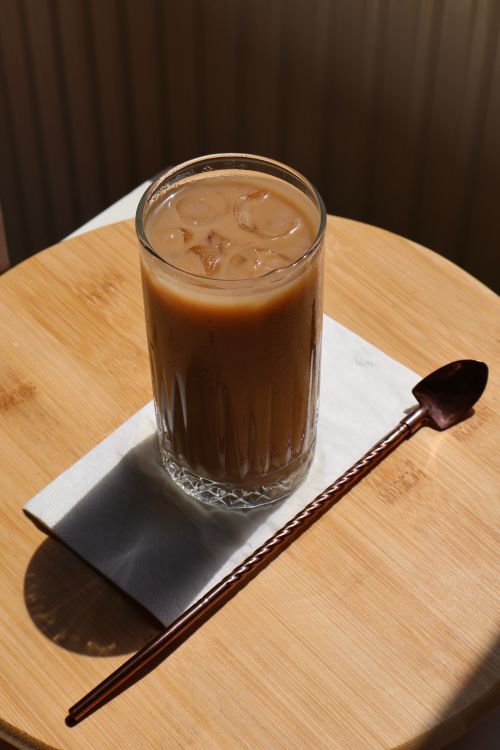Free A refreshing glass of iced coffee on a napkin with a copper spoon nearby. Stock Photo