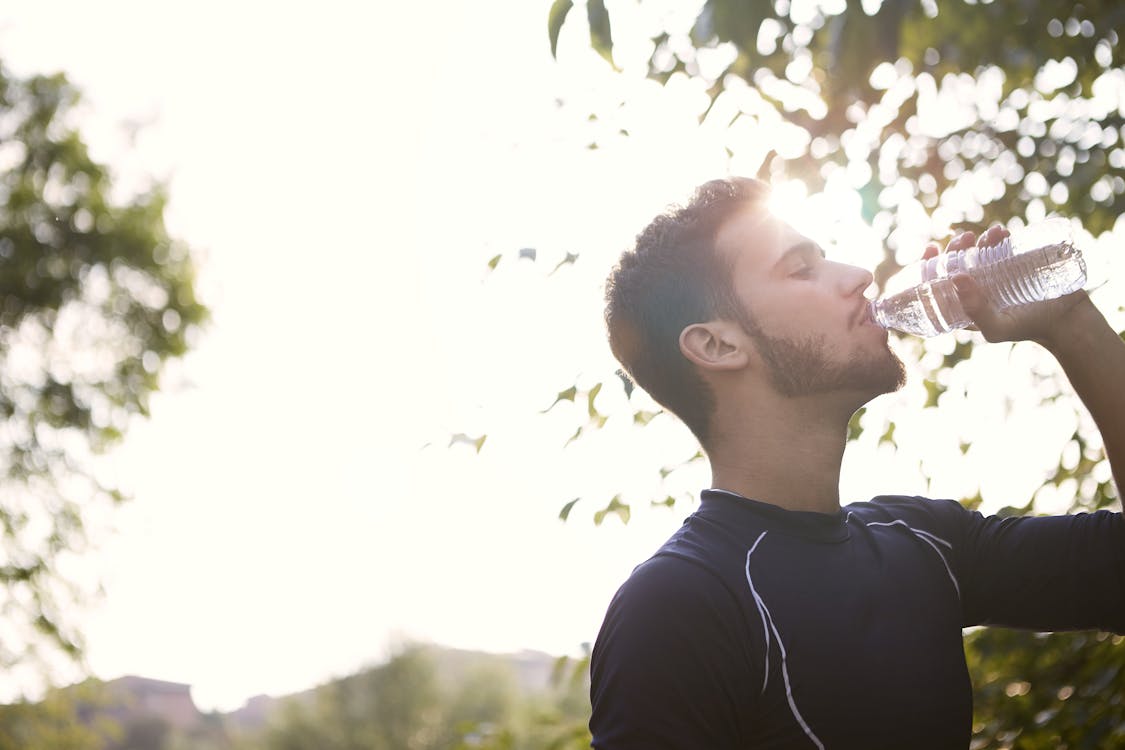 Man in Black Crew Neck Shirt Drinking Water