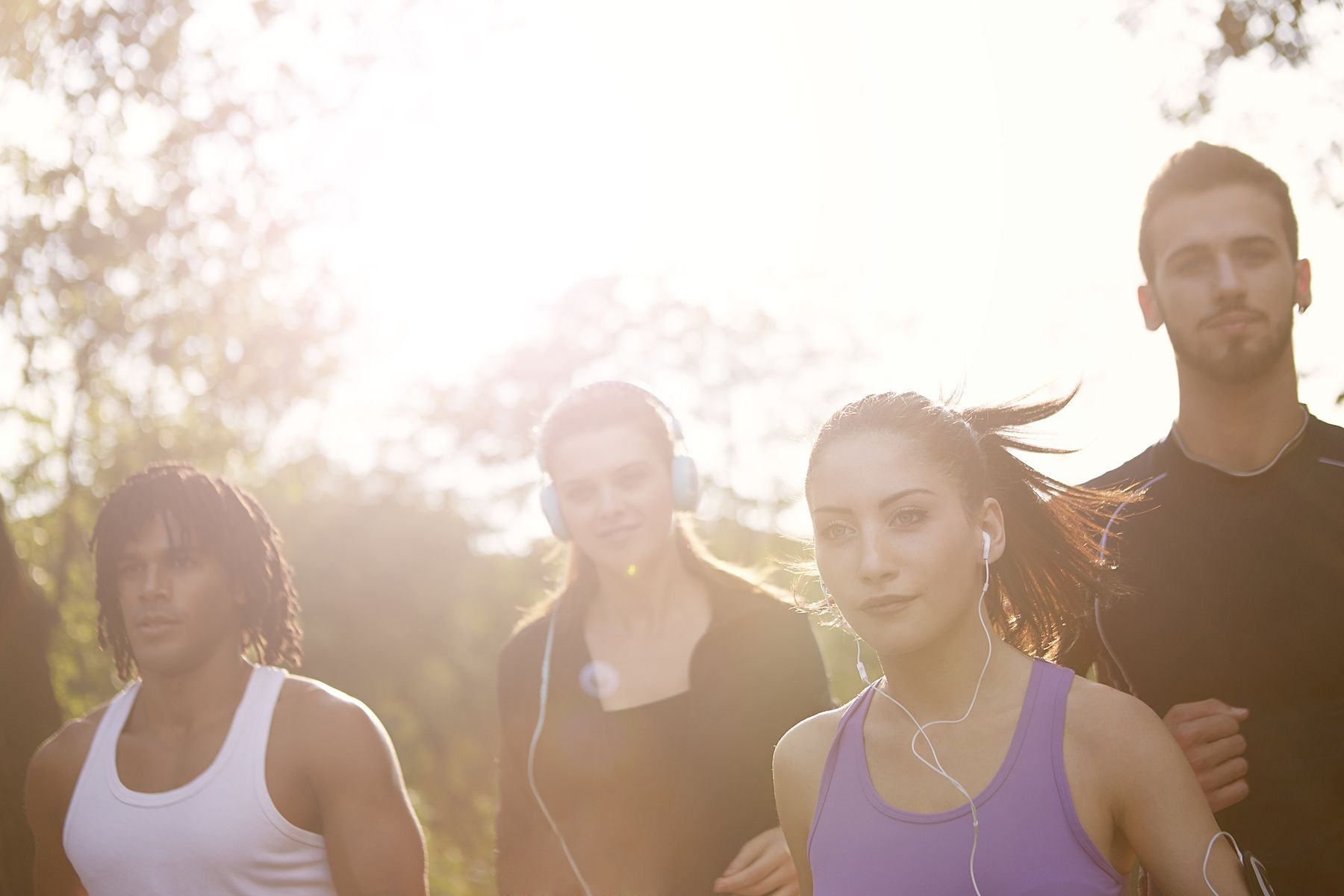 Vier volwassenen joggen samen in de zon