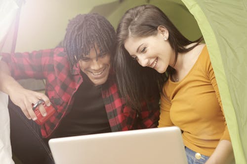 Lovely Couple Watching Movie Inside of Fabric Shelter