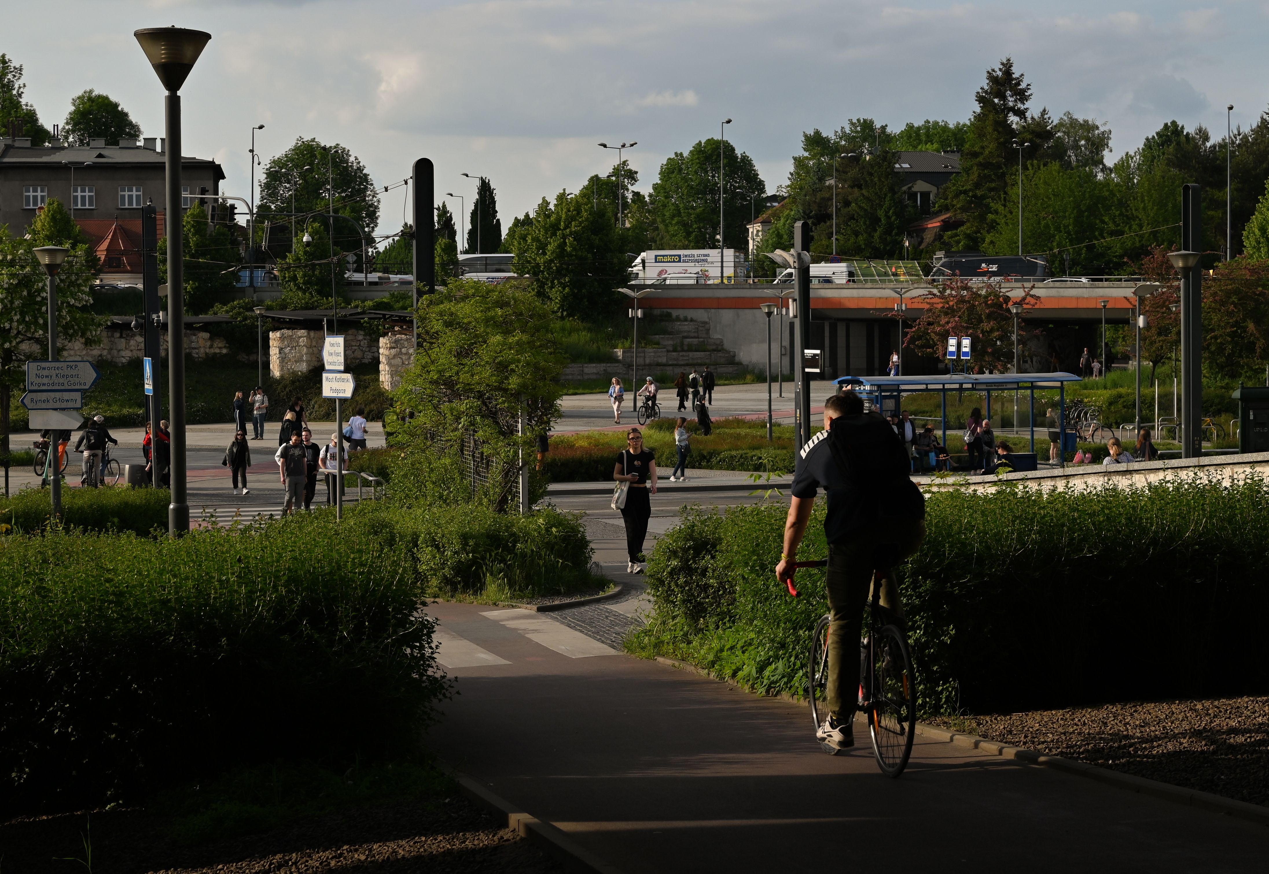 A cyclist rides through a busy street in Krakow, Poland, on a summer day.