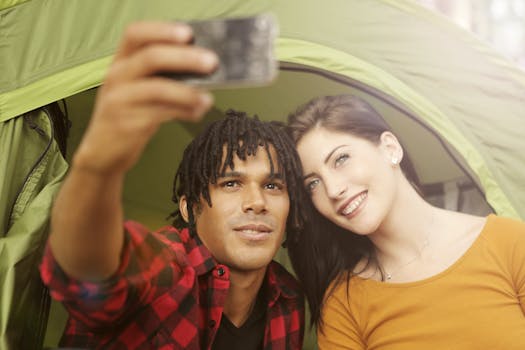 Happy couple enjoying a moment together outdoors while taking a selfie with a smartphone.