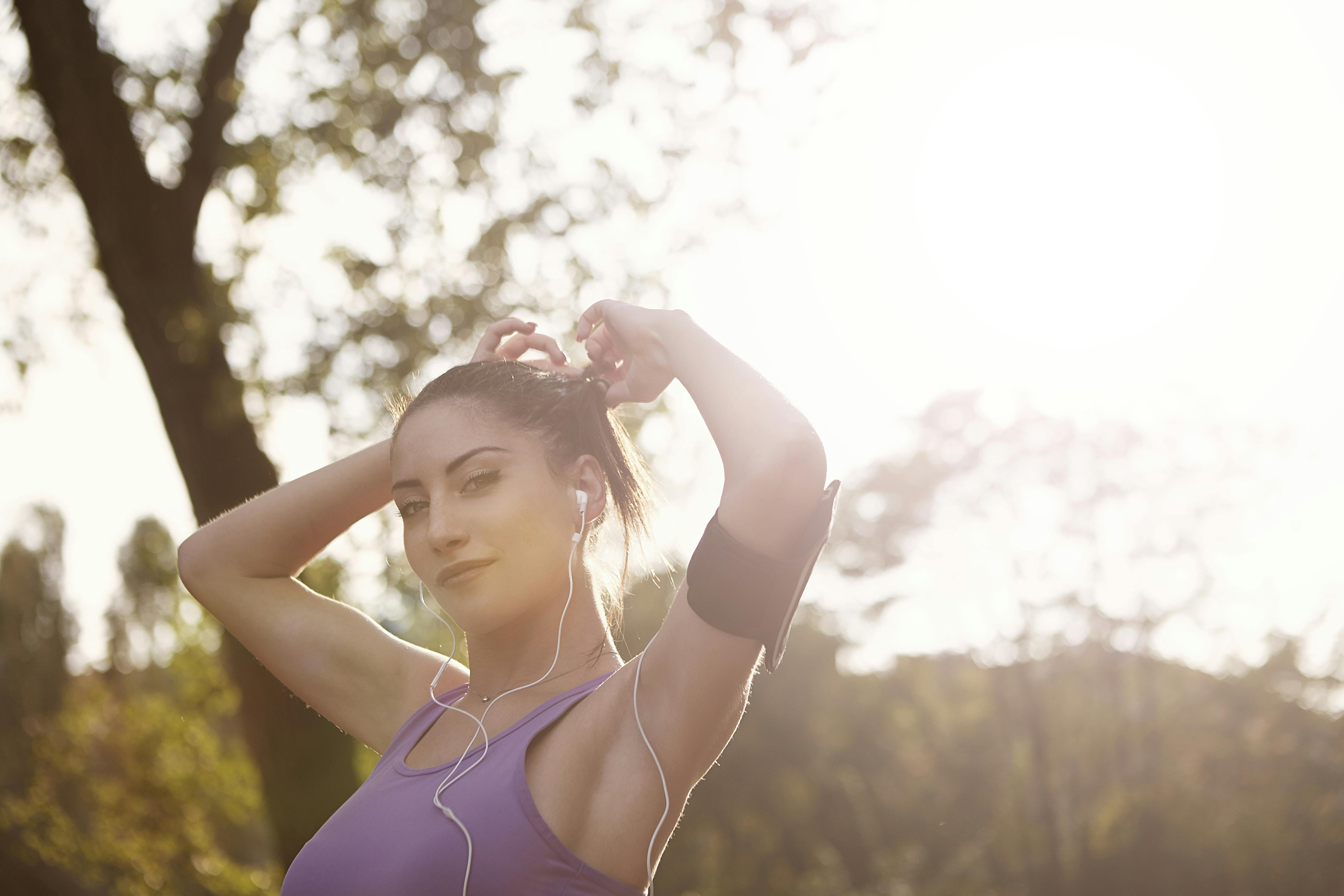 一个女人在户外阳光下锻炼，微笑着享受轻松的运动