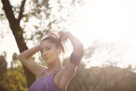 一个女人在户外阳光下锻炼，微笑着享受轻松的运动