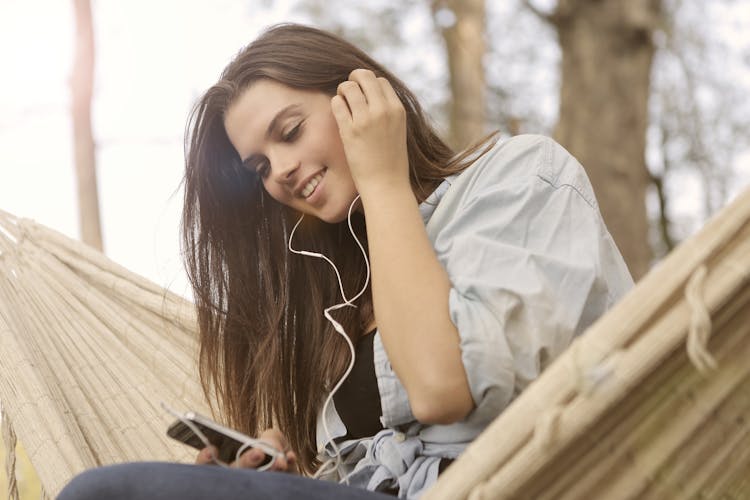 Woman In White Button Up Shirt While Listening To Music