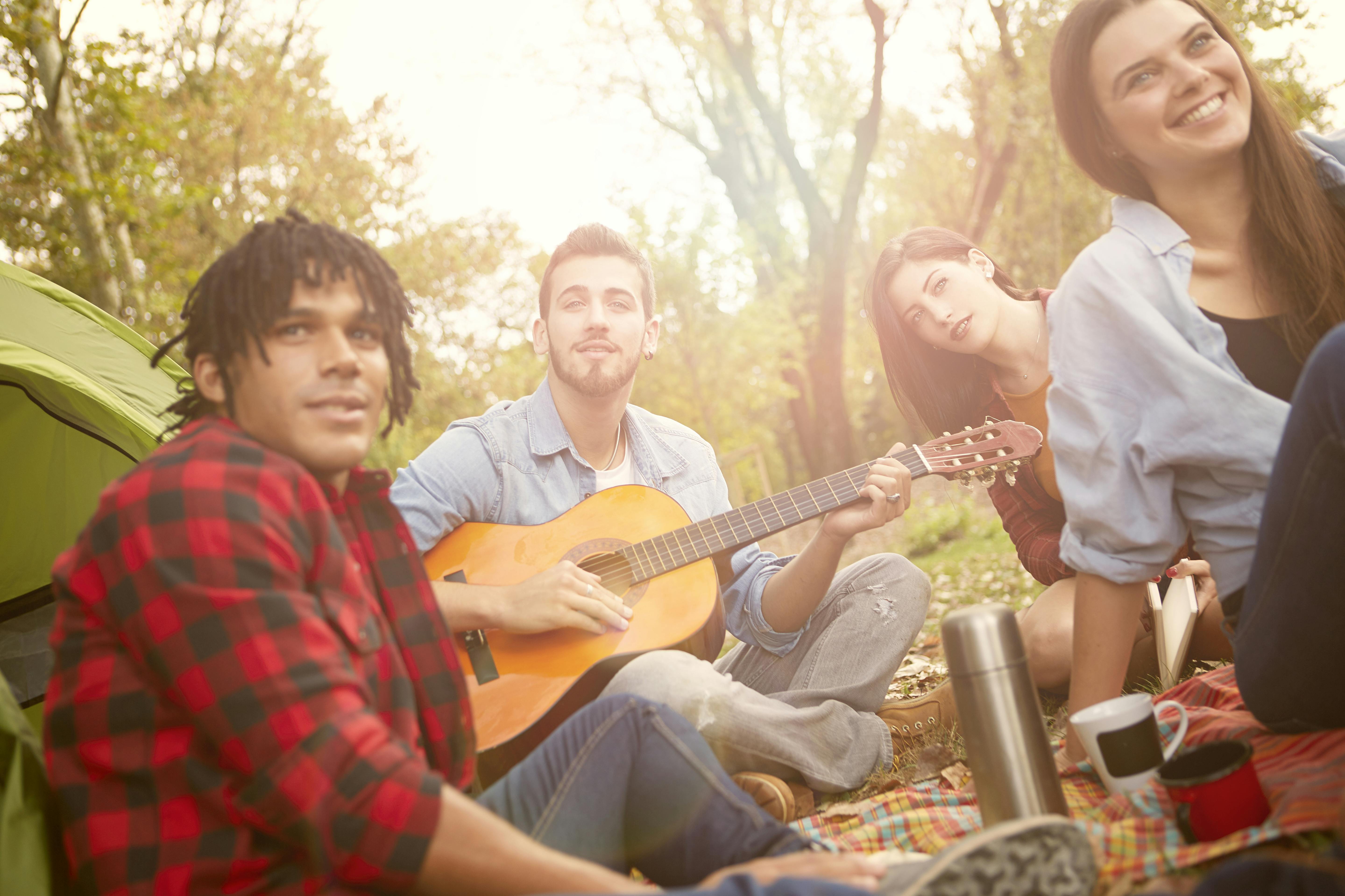 man strumming on acoustic guitar