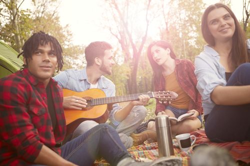 Free Friends relaxing outdoors with guitar, enjoying music and leisure time in nature. Stock Photo