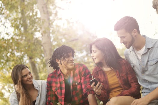 Group of young friends laughing and enjoying time together outdoors in a sunny park.