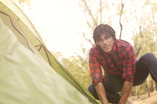 Man in Red and Black Plaid Long Sleeve Fixing Tent