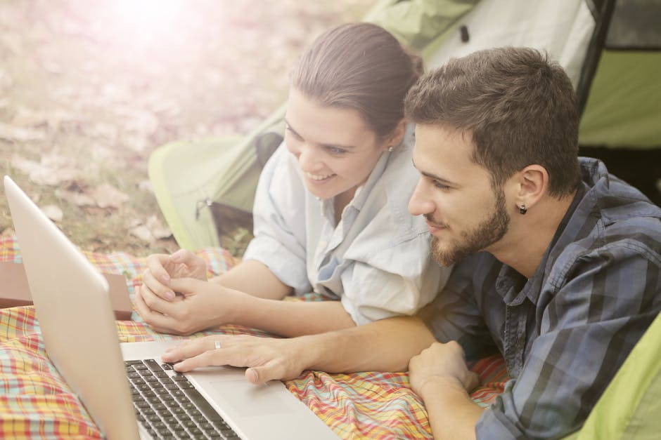 How Garmin Body Battery Solves Daily Energy Dips A young couple enjoying a relaxing day camping with a laptop in a sunny outdoor setting.