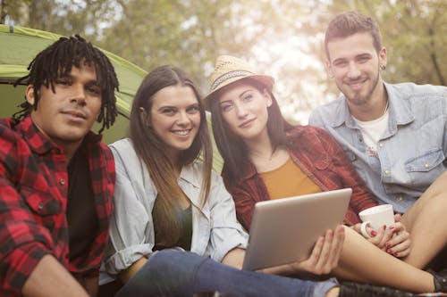 Free People Sitting on Grass Beside Green Tent Stock Photo