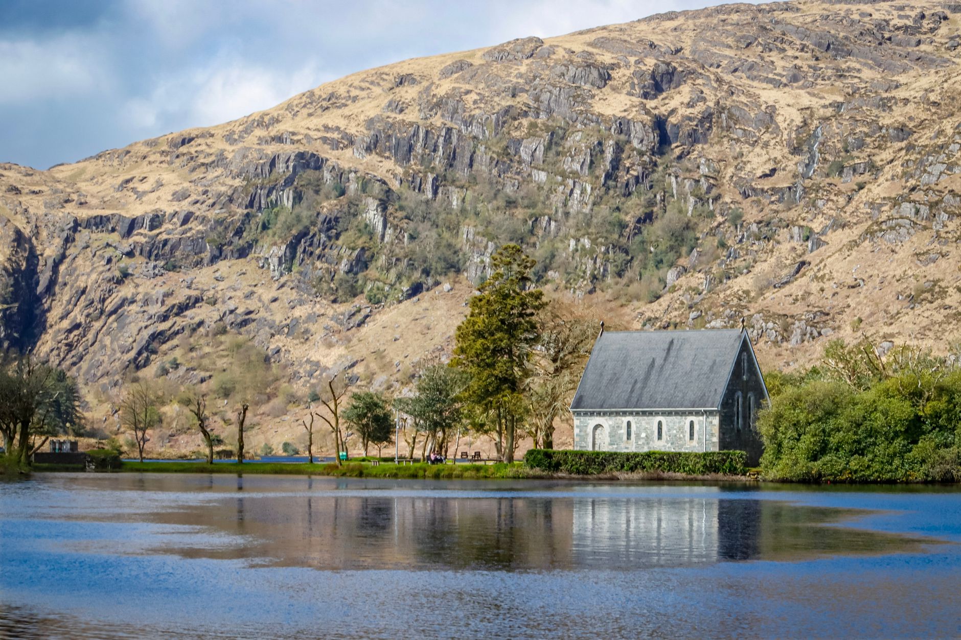 Picturesque view of St. Finbarr's Oratory with dramatic mountains in Gougane Barra, Ireland.