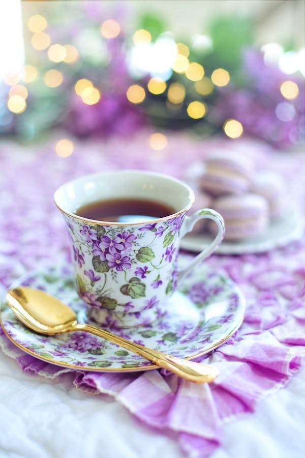 Lavender tea in a white and purple floral ceramic mug on saucer for better sleep naturally