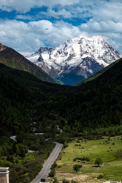 Free Stunning view of snow-capped mountain in Sichuan, China, surrounded by lush greenery and clear sky. Stock Photo