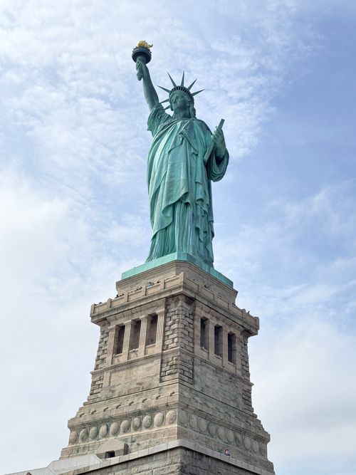 Free The Statue of Liberty standing tall against a clear blue sky in New York City. Stock Photo