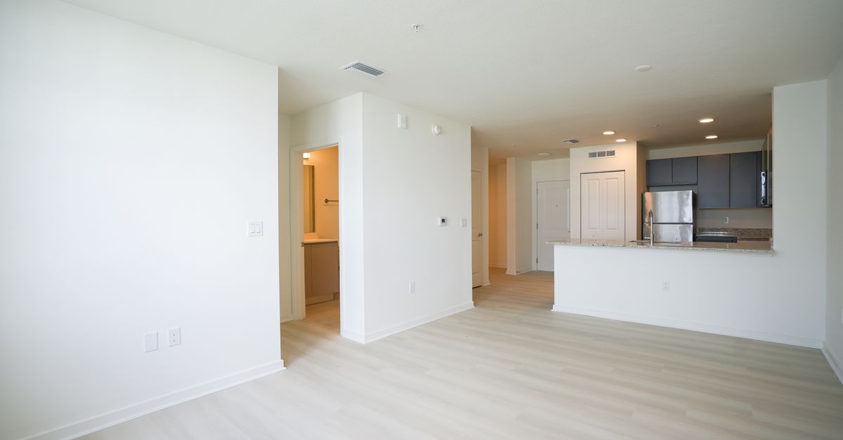 Bright open-plan layout with a modern kitchen featuring stainless steel appliances.