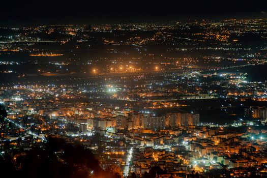 Breathtaking aerial night view of a cityscape illuminated by glowing city lights.