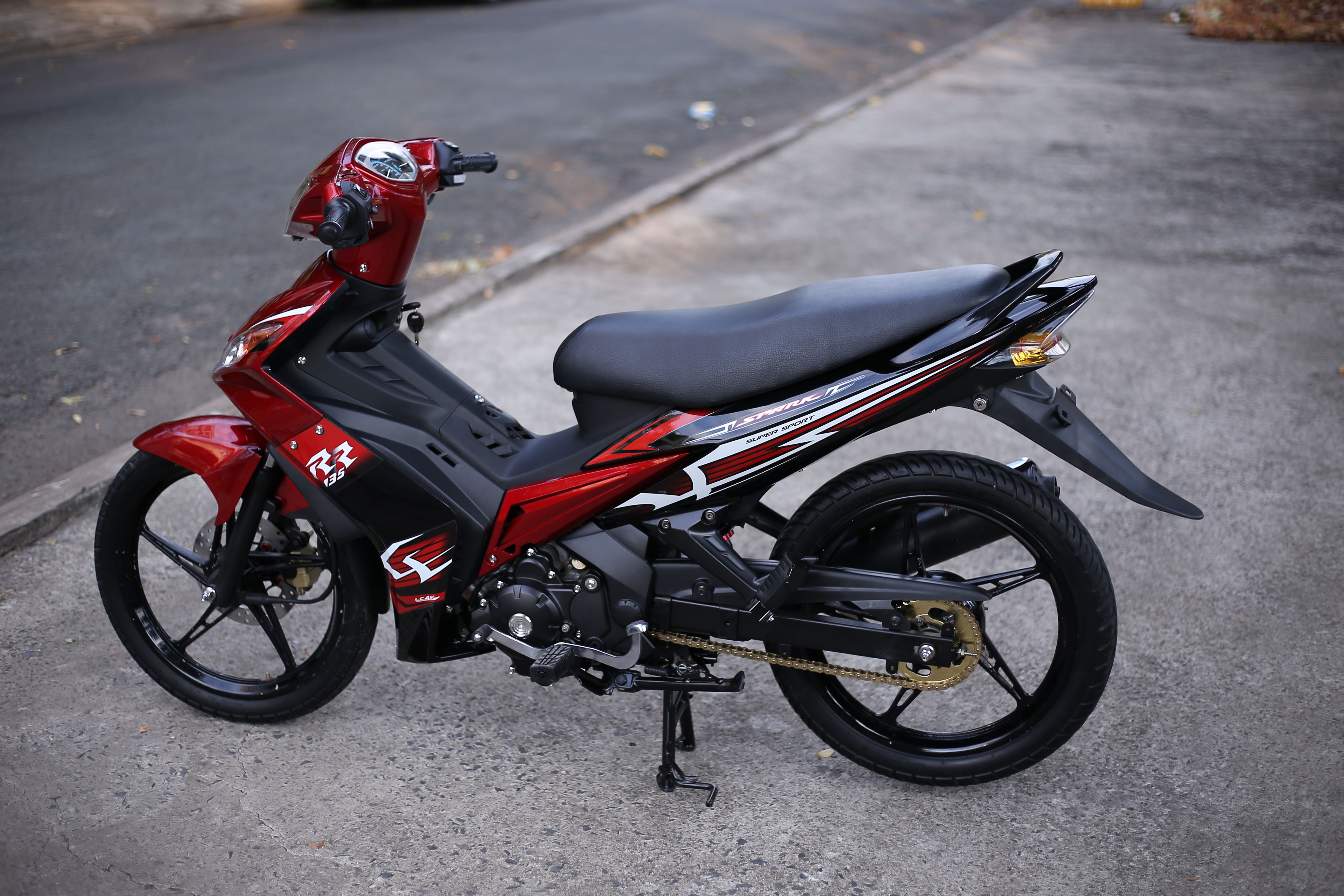 Red sporty motorcycle parked on a city pavement, showcasing modern design and style.