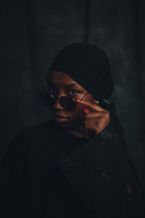Free A striking portrait of a young woman wearing sunglasses and a hijab, showcasing Nigerian fashion and culture. Stock Photo