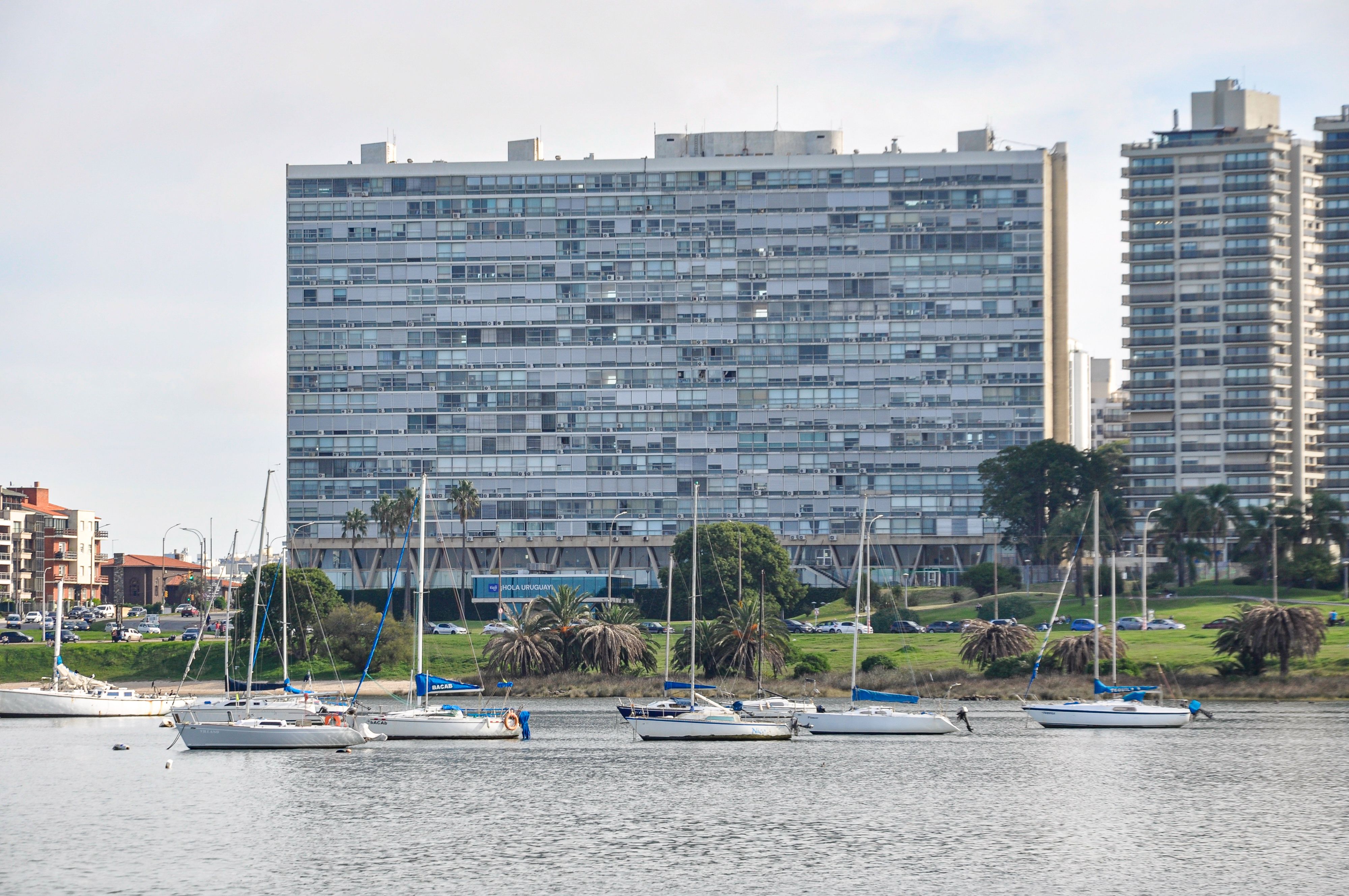 Yachts floating in front of Montevideo's waterfront skyline, showcasing urban landscape.