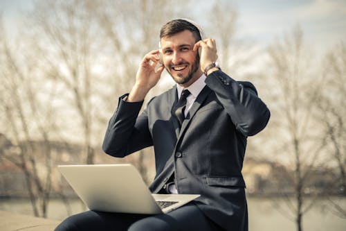 使用macbook的黑色西裝外套的男人