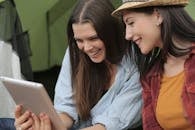 Photo of Women Smiling While Looking at Ipad