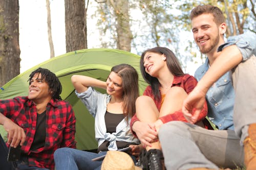 Group of cheerful friends enjoying sunshine in forest