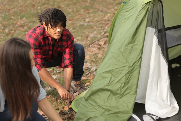 Diverse Man And Woman Pitching Tent