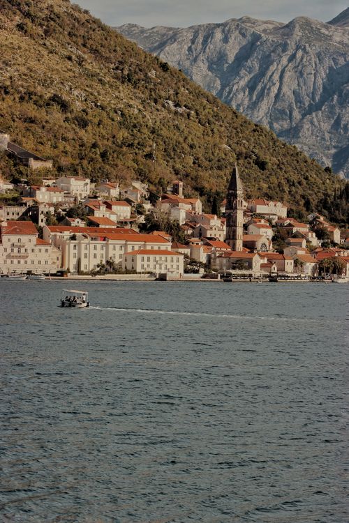 Free Charming coastal village in Karadağ with mountains, historic architecture, and a serene waterfront view. Stock Photo