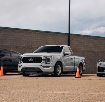 Silver Ford F150 truck parked outdoors in a Colorado Springs lot with traffic cones.