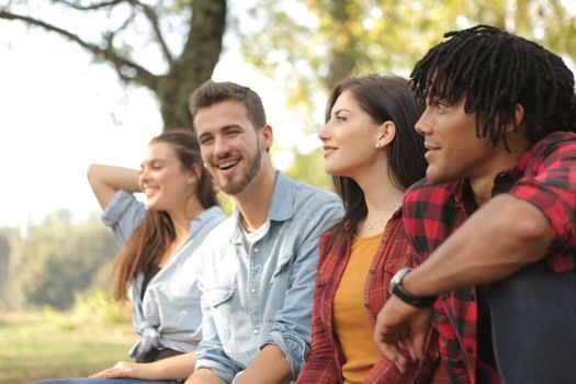Cheerful couple in denim laughing while man and woman in checkered shirts smiling and looking away