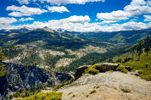 Free Expansive view of Yosemite National Park's mountains and valleys under a bright blue sky. Stock Photo