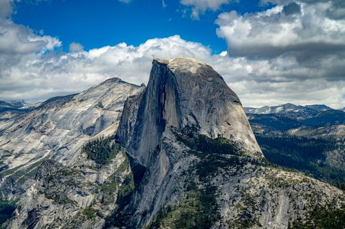 Free Majestic Half Dome in Yosemite National Park under a stunning blue sky and scattered clouds. Stock Photo