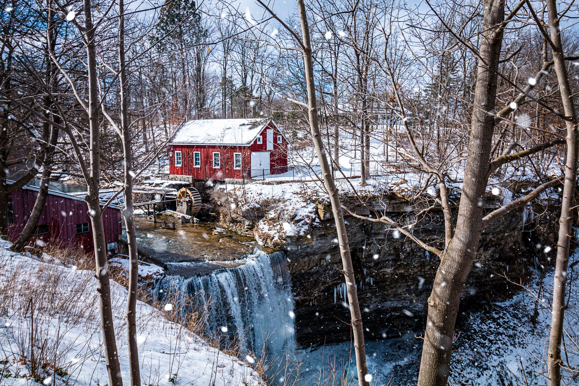 A picturesque red barn and watermill surrounded by snowy scenery in St. Catharines, Ontario, Canada.