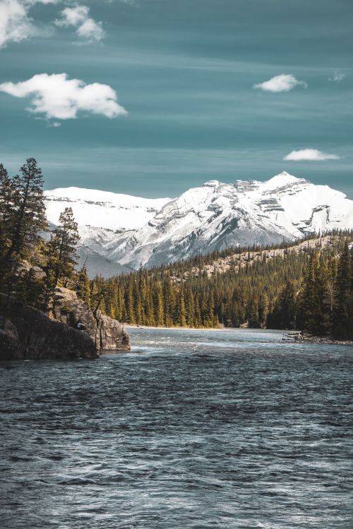 Free Scenic landscape of snow-capped mountains and river in Banff National Park during daytime. Stock Photo