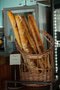 Freshly baked baguettes displayed in a wicker basket at a São Paulo bakery, invoking a rustic charm and authentic flavor.