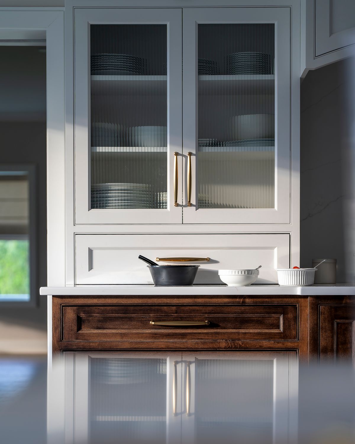 Refined modern kitchen with cookware, white cabinetry and warm wooden details