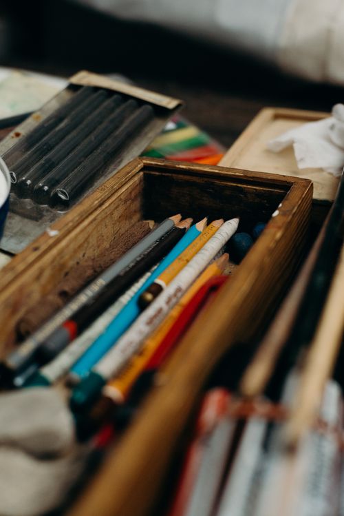 Free Assorted colored pencils in a rustic wooden box, perfect for artists and creatives seeking inspiration. Stock Photo