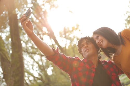 Photo of Man and Woman Taking Selfie Using Smartphone