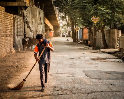 A street sweeper cleans a quiet urban street at sunrise, embodying everyday life and city sanitation.