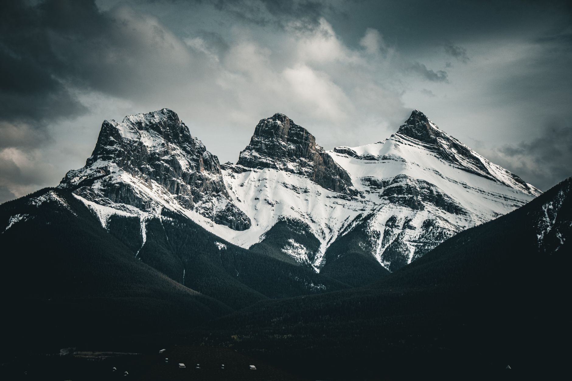 Rocky Mountain peaks under a dark Alberta sky at dusk