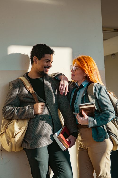 Free Two university students engaging in a casual conversation inside a building. Stock Photo