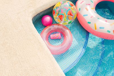 Inflatable rings floating at the edge of a turquoise pool, by Brunxs on Pexels