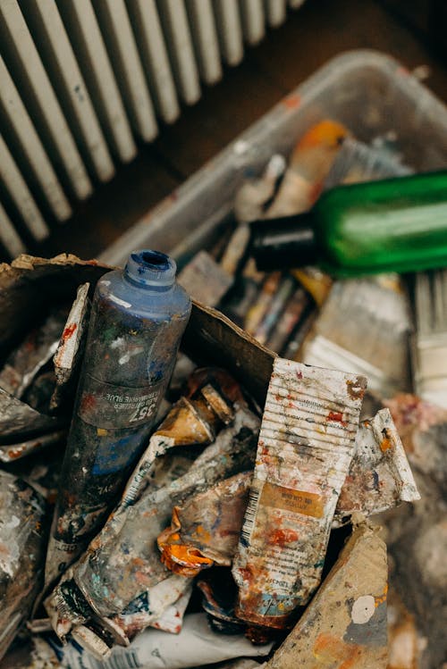 Blue and Green Plastic Bottle on Top of Tube Containers