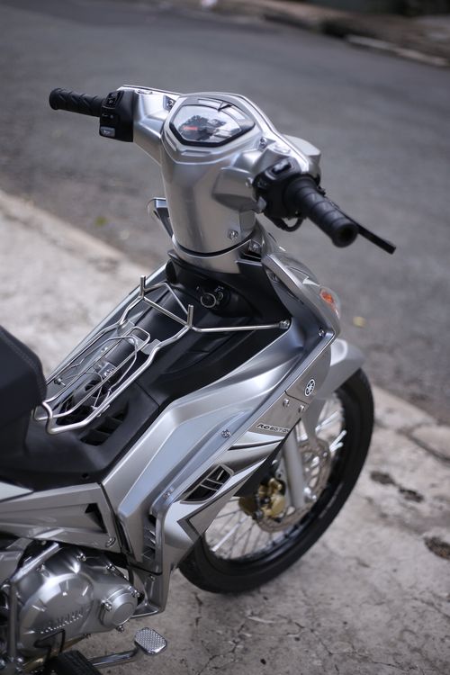 Free Detailed view of a sleek silver motorcycle parked on an urban street. Stock Photo