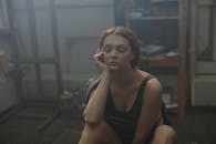 一位年轻女子的肖像在昏暗的艺术工作室里陷入沉思