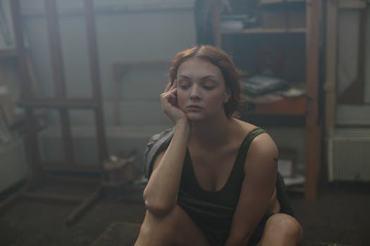 一位年轻女子的肖像在昏暗的艺术工作室里陷入沉思