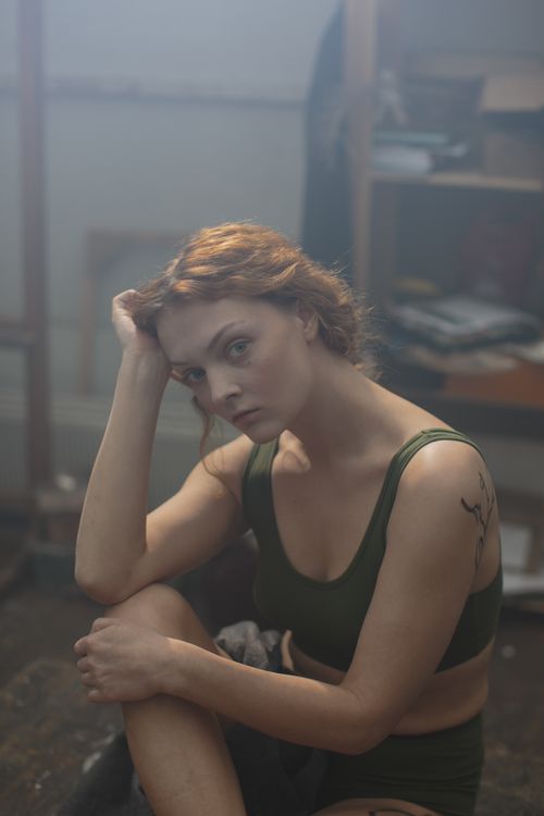 Free Woman in an artistic studio wearing casual attire, deep in thought, highlighting beauty and serenity. Stock Photo