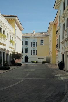 Quiet Mediterranean style residential street with pastel buildings under clear skies.