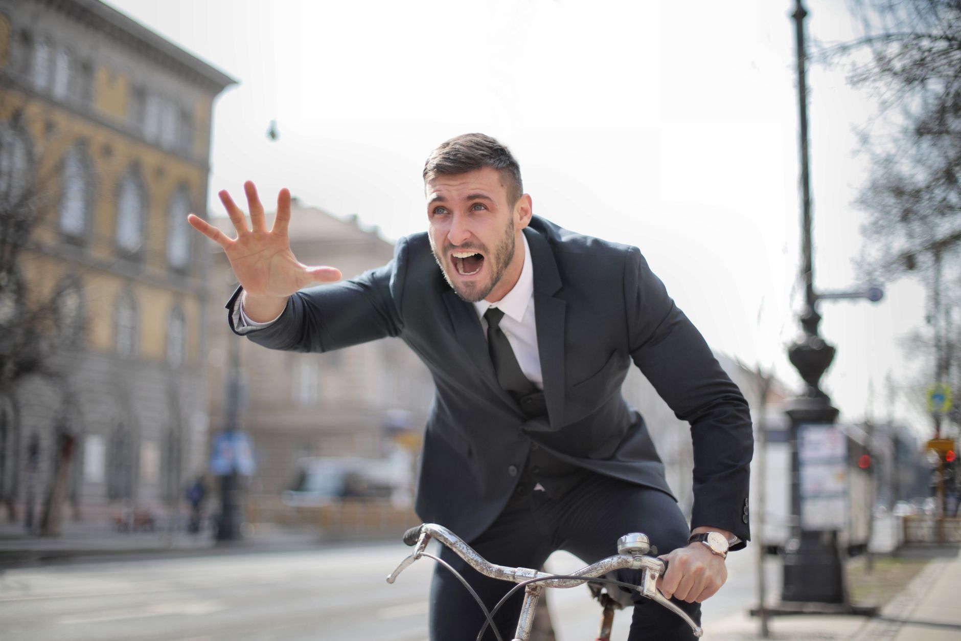 心理健康與現代生活的拉鋸戰:實用守護指南 Corporate professional in a suit rides a bike swiftly through city streets expressing urgency.